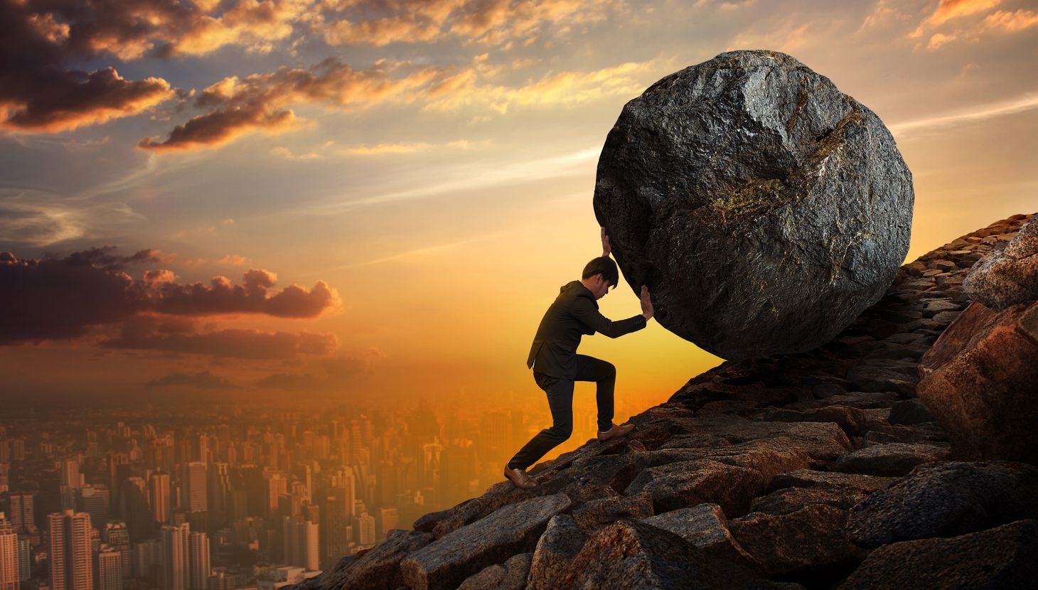 Image of man rolling rock up the hill signifying hard work